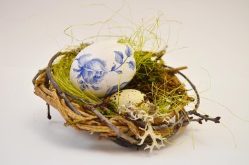 Obraz premium A cute wicker nest with a stingy egg and moss. Easter decoration. Moss. Quail egg.
