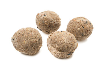 Four bird fat balls with shadow seen from high angle and isolated on white background
