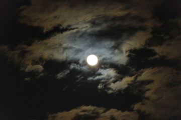 Naklejka na ściany i meble Photo of the moon in the clouds at night