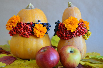 Autumn floral bouquet in a pumpkin vase for Halloween. Apples. Fall decoration with pumpkin