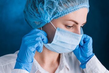 female doctor puts on a mask