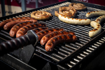 A lot of sausages lies on a grill