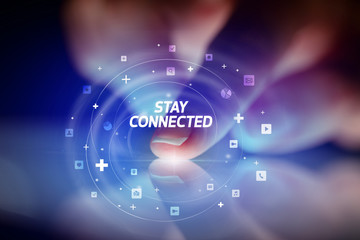 Finger touching tablet with social media icons and STAY CONNECTED