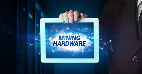 Young business person working on tablet and shows the inscription: MINING HARDWARE