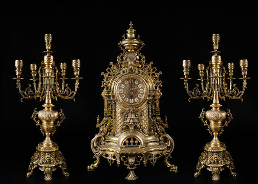 vintage gold watch with candelabra on black background, bronze clock and candelabra, gold candlesticks and clock, antique clock and candlesticks, vintage clock with chandeliers on a black background