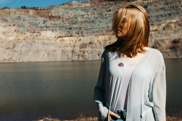 Close up photo of female hands with handmade jewellery,  rings, necklace, bracelet. Outdoors photo with lake in background.