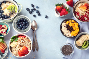 Bowls of oatmeal with berries and fruits  for healthy breakfast. Food with vitamins, minerals and antioxidants. Top view with copy space