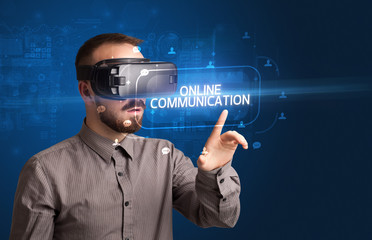 Businessman looking through Virtual Reality glasses with ONLINE COMMUNICATION inscription, social networking concept