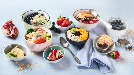 Fototapeta na wymiar Bowls of oatmeal with berries and fruits for healthy breakfast. Food with vitamins, minerals and antioxidants.