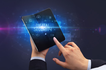 Businessman holding a foldable smartphone with DIGITAL SECURITY inscription, cyber security concept