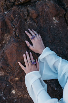 Close up photo of unrecognisable model hand wearing few purple handmade floral rings- beauty and jewellery concept. 
