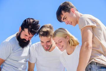What is there. Group people excited look down. Woman and men happy sky background. Happiness in unity. Open mind for happiness. Carefree youth hang out together. See something adorable. Happiness