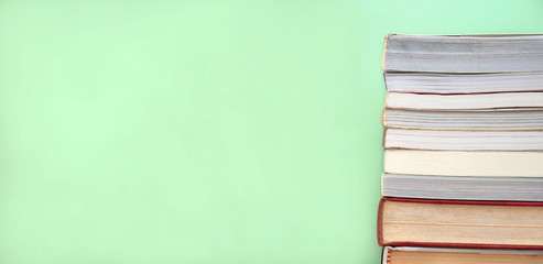 Stack of books on green background with copy space. Education and learning background.