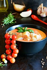 Spanish gazpacho tomato soup with fresh herbs, vegetable salsa and croutons. Tasty refreshing lunch. Vegan food, healthy eating concept.