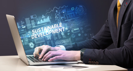 Businessman working on laptop with SUSTAINABLE DEVELOPMENT inscription, cyber technology concept
