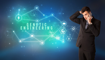 Businessman in front of cloud service icons with GENETIC ENGINEERING inscription, modern technology concept