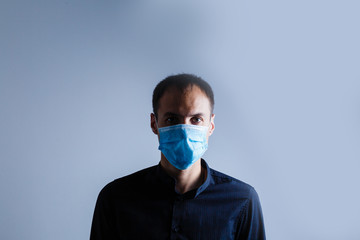 Strong man wearing mask to prevent flu virus and dust air pollution on white background