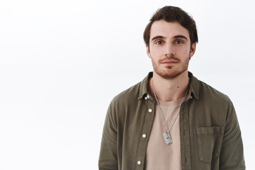 Close-up portrait of handsome smiling young man with beard and moustache standing in casual outfit...