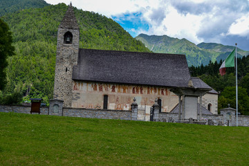 Fototapeta na wymiar chiesa di montagna con torre e cimitero