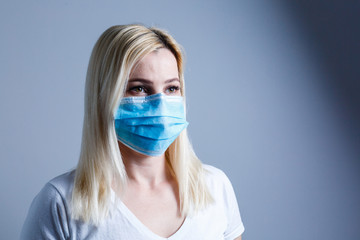 an attractive young woman wears a paper face mask to protect herself from the H1N1 Virus, isolated, with room for your text
