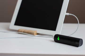 power Bank charges your tablet on a wooden stand