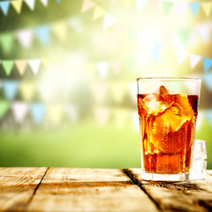 Fresh cold ice tea in glass and blurred landscape of park.Copy space for your composition. 