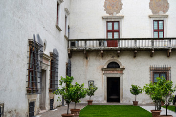 Fototapeta na wymiar cortile antico palazzo con balcone e finestre con sbarre 
