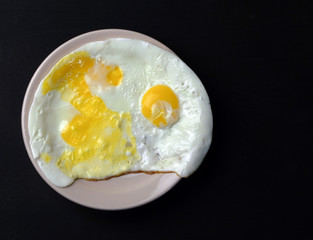  tasty egg lies on a plate on a black background