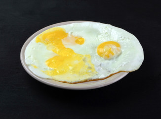  three fried eggs lie on a plate