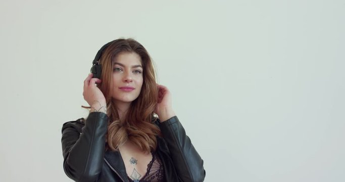 Music fades, girl takes off headphones and places them over the camera's "ears"