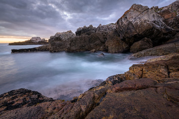 Fototapeta na wymiar A beautiful early evening seascape photographed on a stormy day after sunset in Hermanus, South Africa.