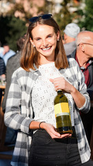Young smiling girl wears sunglasses holds wine bottle