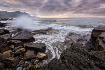 A beautiful early morning seascape photographed on a stormy day at sunrise in Hermanus, South Africa.
