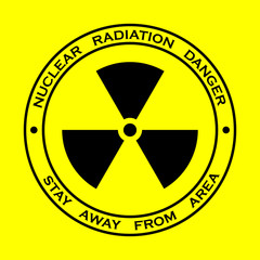 Black sign for nuclear radiation on yellow background, with warning text around the shape