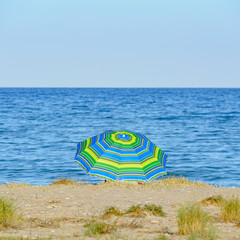 Sombrilla colorida en un día soleado junto al mar Mediterráneo. España