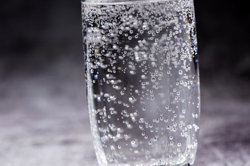 Glass of sparkling water on the grey background