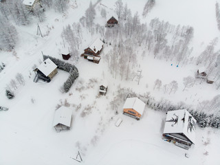 Winter landscape photo of snow covered fields and cottages with bare Tree 