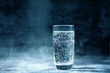 Glass of sparkling water on the grey background
