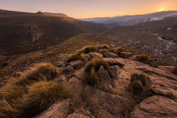 A tranquil snow-covered mountain landscape taken in Lesotho, on golden evening just after sunset.