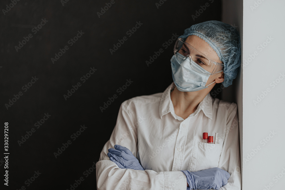 Wall mural tired medical worker doctor after taking a large number of patients due to the epidemic of coronavir