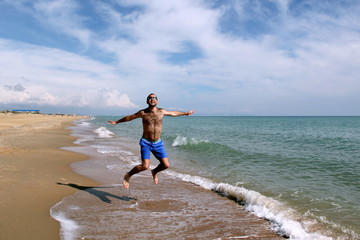 Young man on the sea in blue shorts