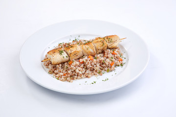 chicken kebab with buckwheat on the white plate