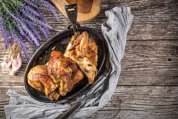 Quarters of fried chicken in a cast iron skillet.