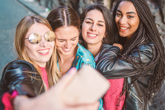 Group of multiracial four Girls taking selfie with their smartphone lifestyle. Woman friendship lifestyle concept. Happy multiethnic millennial students enjoying life together.