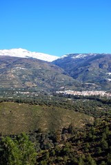 Fototapeta na wymiar View of the town and countryside in the Vale of Lecrin with views towards the snow capped Sierra Nevada mountains, Orgiva, Spain.