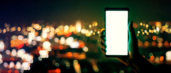 smartphone social media close up famale hand touch blank screen mock up device screen smartphone with blur bokeh cityscape building light flare effect business technology connection