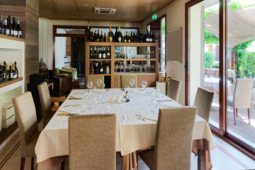 Retro restaurant interior with wine shelves and tables with chairs