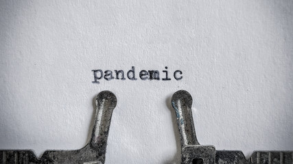 pandemic text typed on blank sheet with an old typewriter in vintage background
