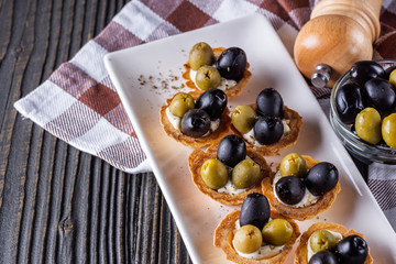 delicious snack tartlets on rustic wooden background
