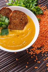 lentil cream soup on rustic wooden background